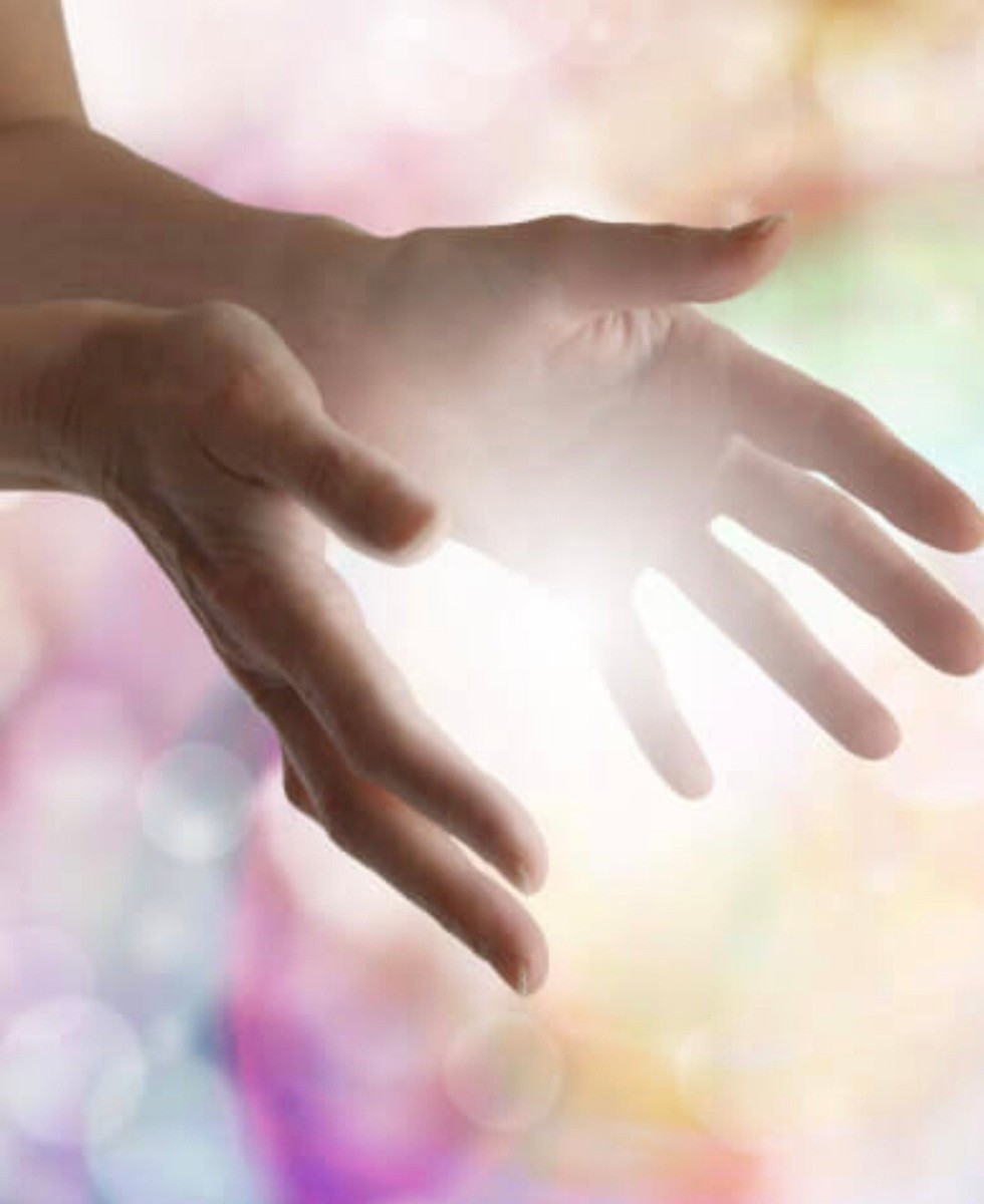 Hender som sender healing-energi i varmt lys